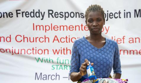 Woman holding supplies. Distribution of materials to communities affected by the Cyclone Freddy that landed in Malawi in March 2023. More than 1000 people died and over 80000 were displaced as houses were damaged rendering these people homeless.