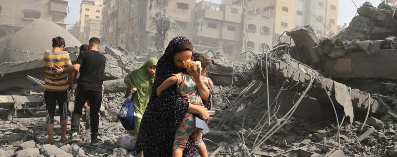 Palestinians evacuate the area following an Israeli airstrike on the Sousi mosque in Gaza City on October 9, 2023. Israel continued to battle Hamas fighters on October 9 and massed tens of thousands of troops and heavy armour around the Gaza Strip