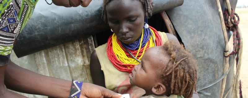 A healthcare worker is checking the weight of Nesi Kulgo Merumaee’s baby to find out if she is healthy. Nesi is happy that her daughter is not malnourished.
