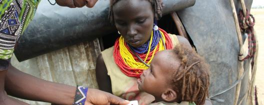 A healthcare worker is checking the weight of Nesi Kulgo Merumaee’s baby to find out if she is healthy. Nesi is happy that her daughter is not malnourished.
